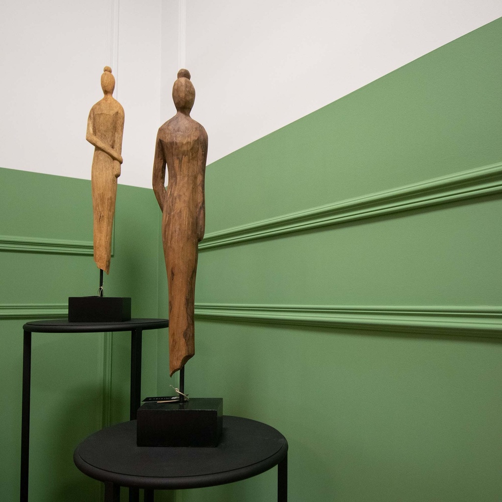 twee houten beelden van vrouwen op zwart metalen sokkels.jpg